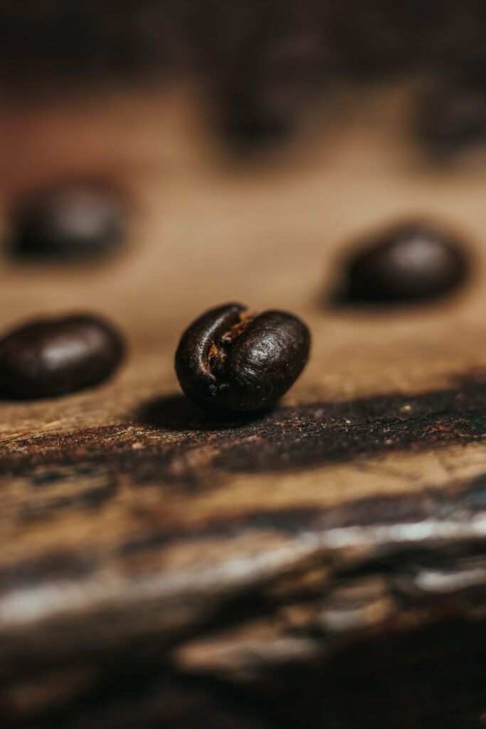Rich Brown Coffee Bean Close-Up on Rustic Wood | Wallpaper Background