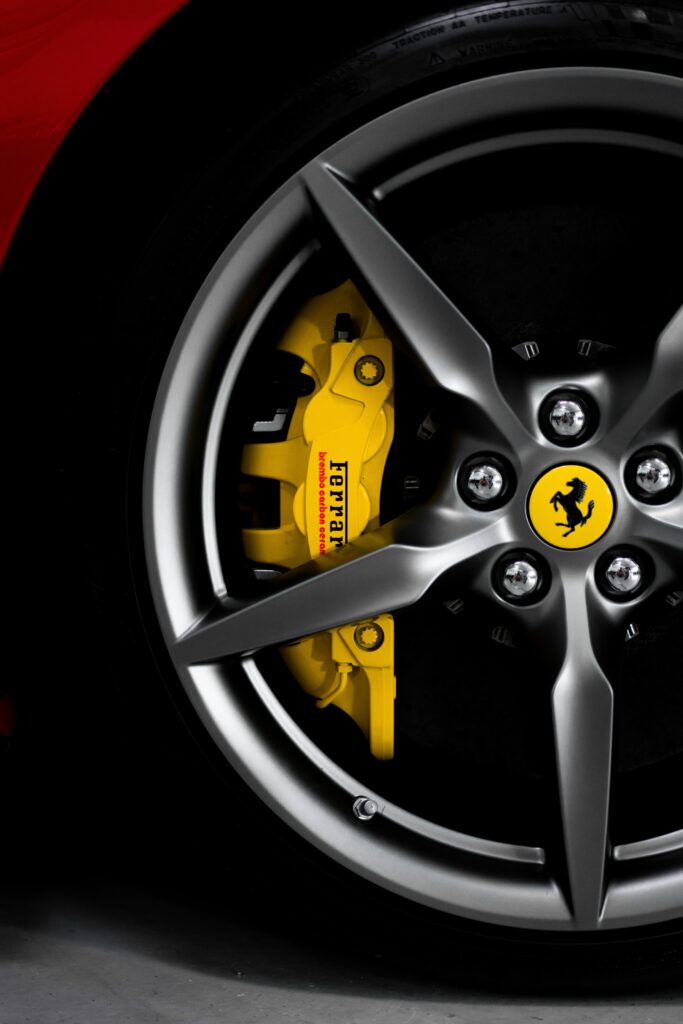 Close-Up of Luxury Ferrari Wheel: Alloy Design & Yellow Caliper Wallpaper