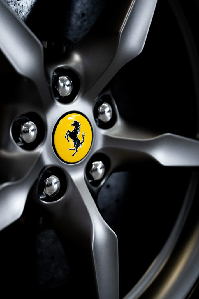 Close-Up of Ferrari Wheel: Luxury Design & Iconic Emblem Wallpaper