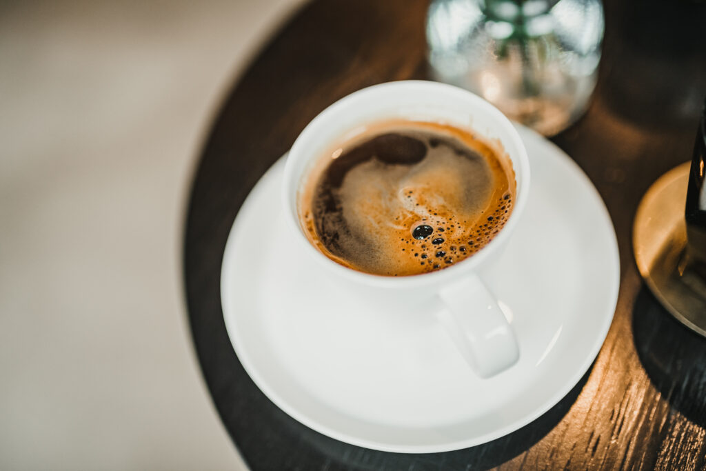 Freshly Brewed Espresso Close-Up: Rich Foam & Color on Wood Background Wallpaper