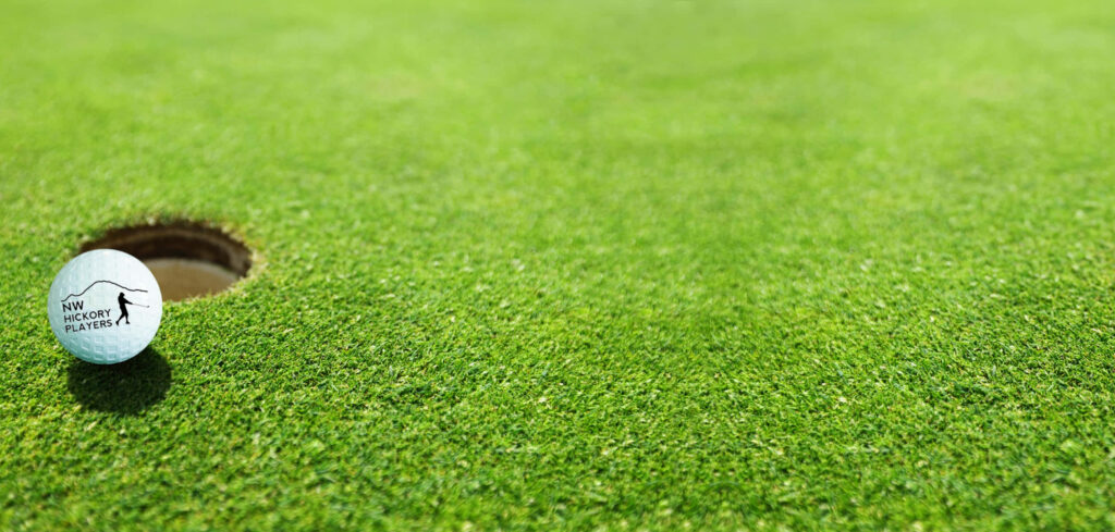 Close-Up Golf Ball Near Hole on Lush Green Course Background Wallpaper