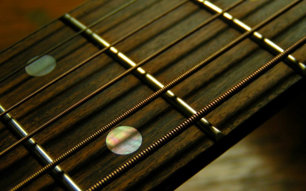 Intricate Guitar Fretboard Close-Up Wallpaper Background