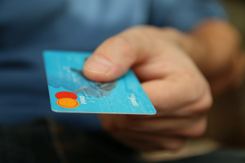 Close-up of hand holding light blue MasterCard debit card showcasing modern finance convenience Wallpaper