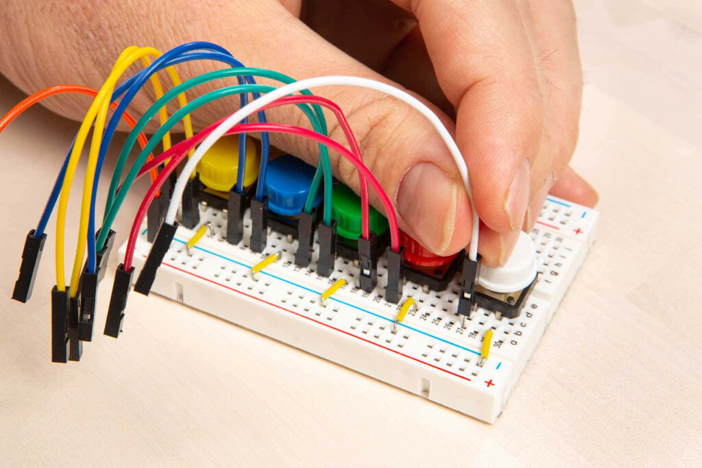 Close-Up: Hand Prototyping on Breadboard with Colorful Wires Wallpaper