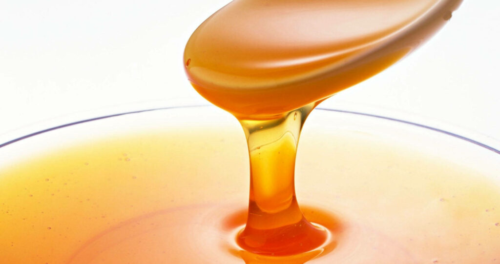 Golden Honey Syrup Dripping: Glossy Close-Up Wallpaper Background
