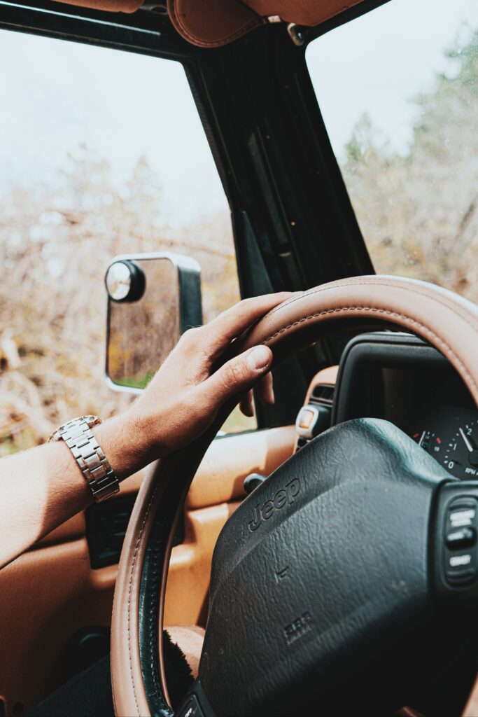 Close-Up of Jeep Steering Wheel with Scenic Outdoor Wallpaper