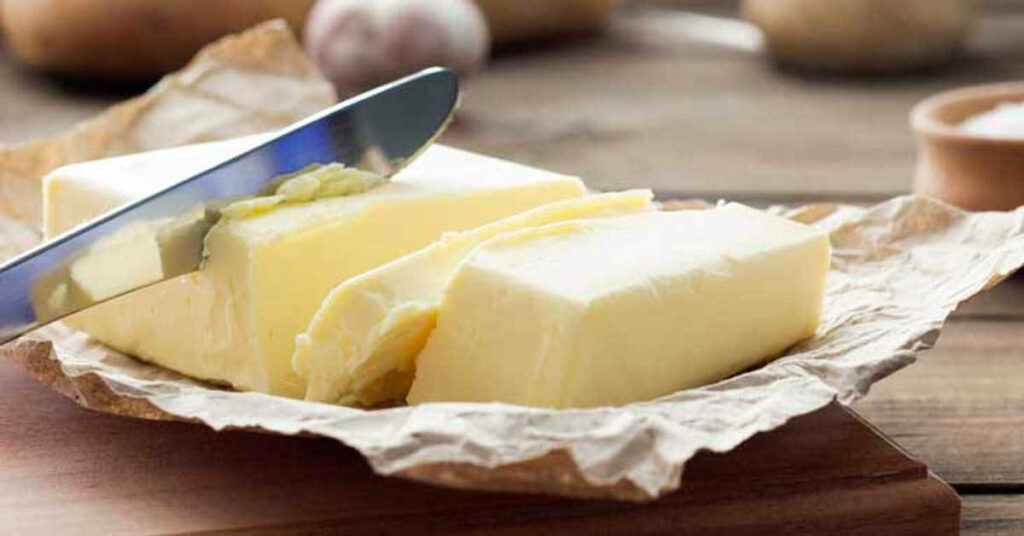 Rustic Wallpaper: Knife Slicing Fresh Butter on Warm Background