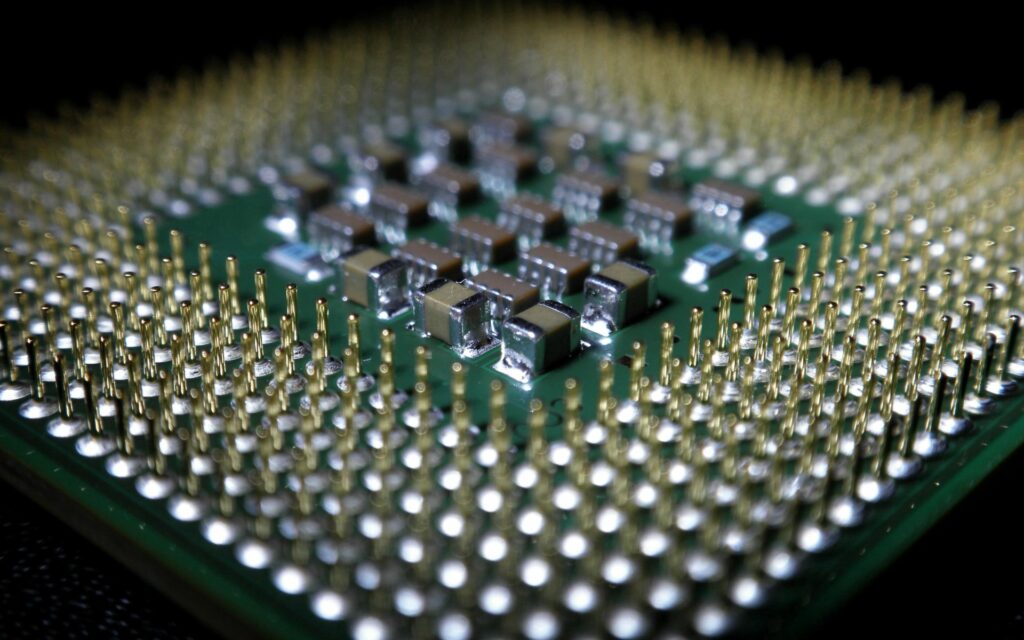 Close-Up Microchip Wallpaper: Intricate Board & Metallic Pins Background