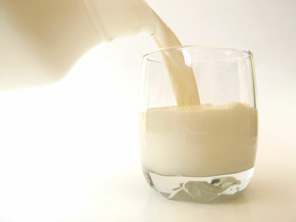Milk Stream Decanter Close-Up Wallpaper on Soft White Background