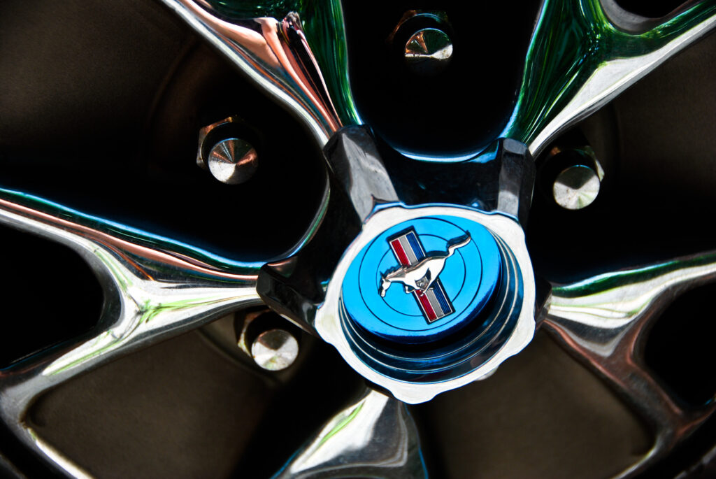 Close-Up Mustang Wheel: Sleek Spokes & Iconic Emblem Wallpaper