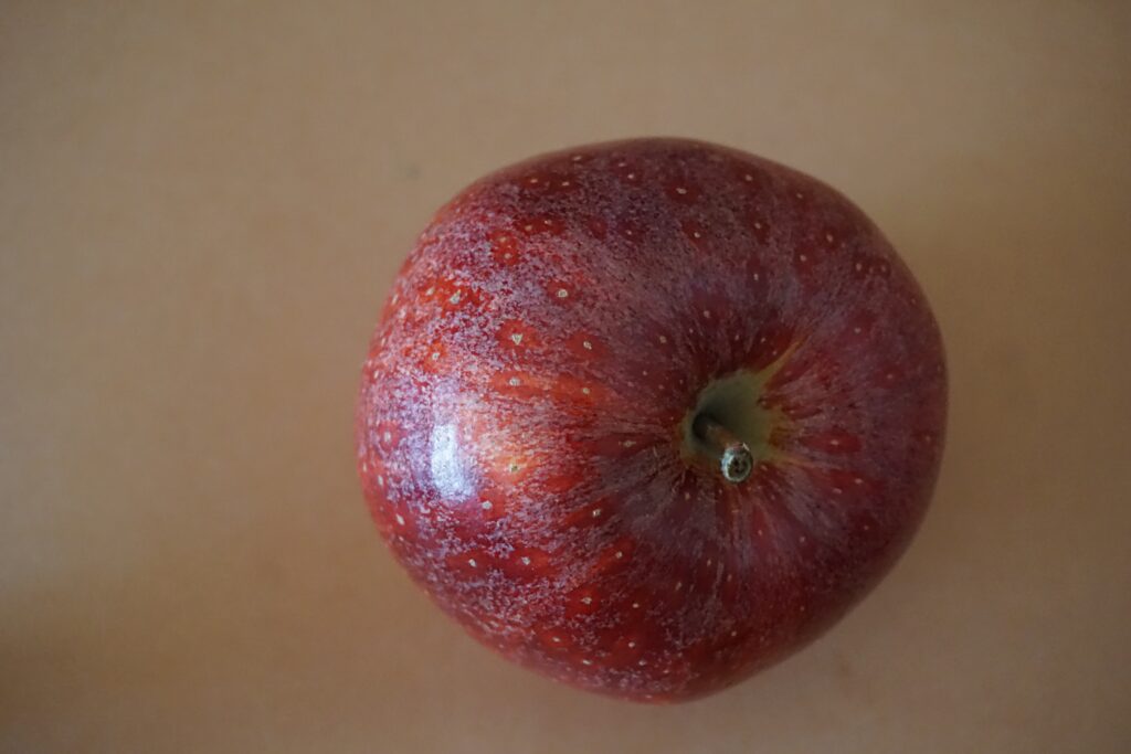 Fresh Red Apple Wallpaper with Water Droplets - Textured Background
