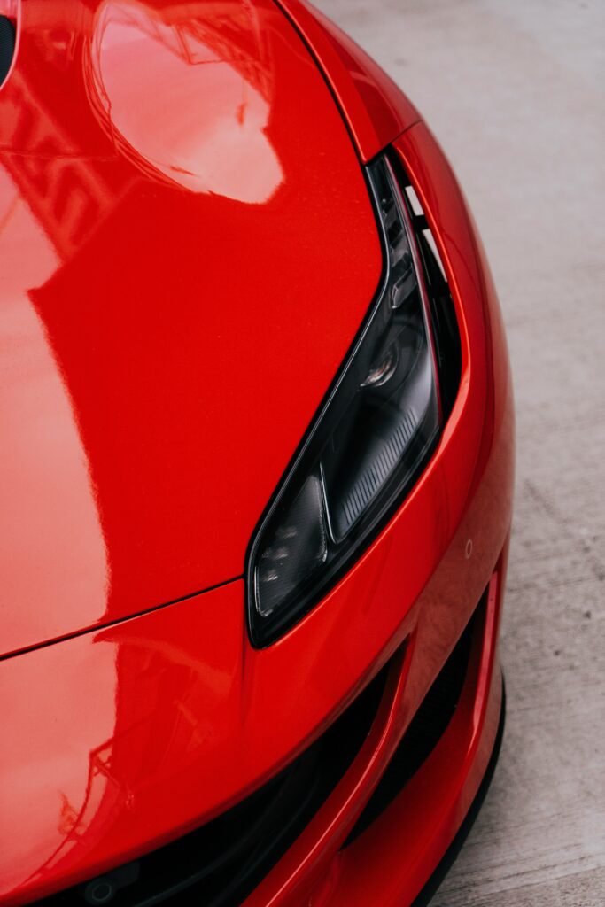 Close-Up Red Car Wallpaper: Sleek Design & Modern Headlight Detail