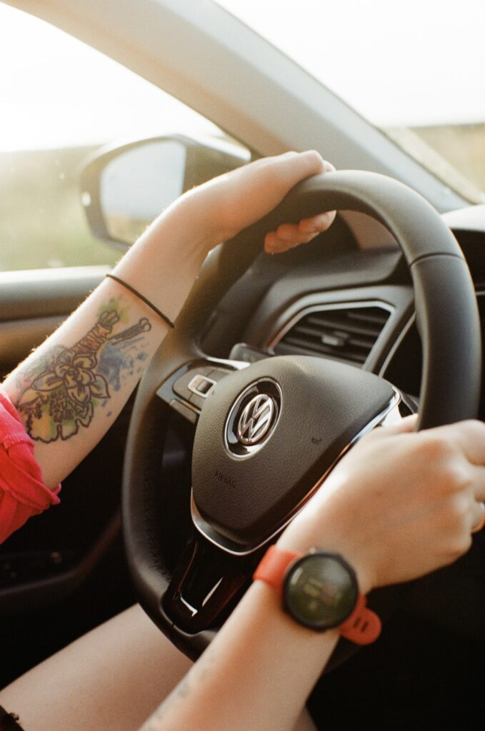 Close-Up of Hands on Volkswagen Steering Wheel: Driving Focus Wallpaper