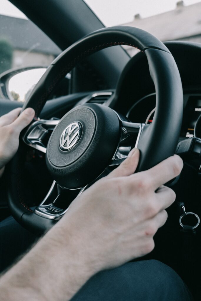 Close-Up Volkswagen Steering Wheel Wallpaper with Logo Background