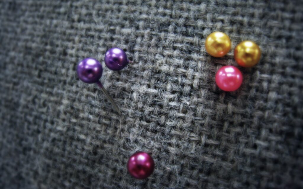 Colorful Beads & Needles: Intricate Crafting Wallpaper Background