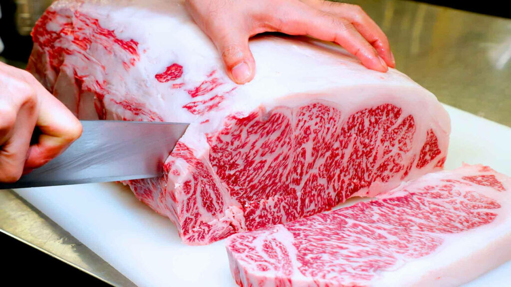 Close-Up Wallpaper: Expert Slicing of Marbled Kobe Beef on Cutting Board