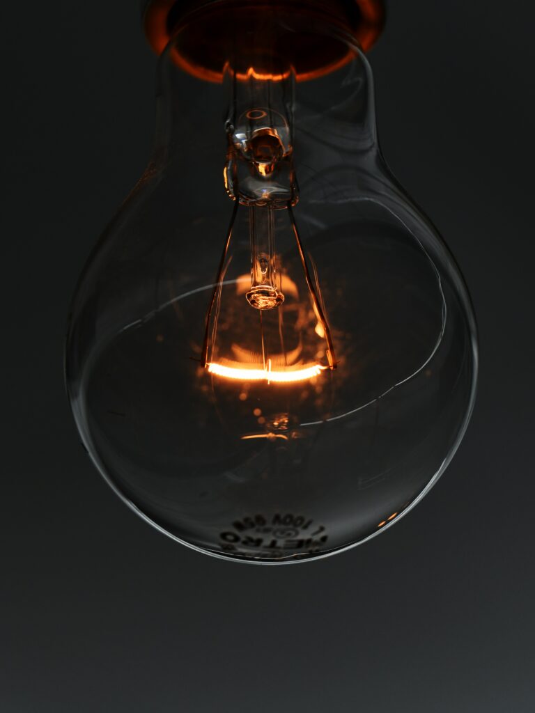 Close-Up Wallpaper of Glowing Light Bulb with Intricate Filament Details