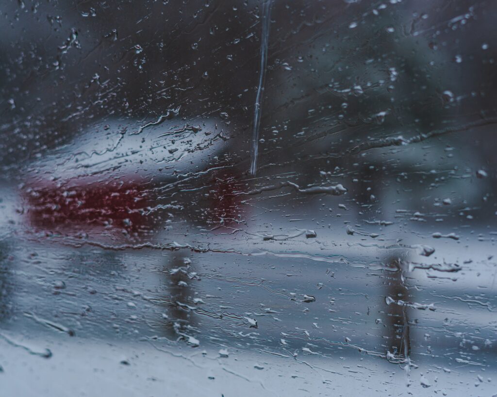 Wet Glass Wallpaper: Raindrops Blurring Snowy Scene & Red Building