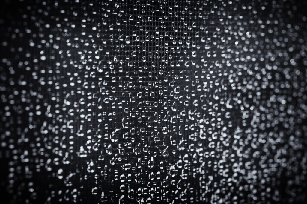 Macro Water Droplets on Dark Grid: Intricate Rain Wallpaper Background