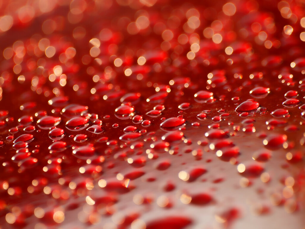 Vibrant Red Wallpaper: Close-Up of Water Droplets Texture