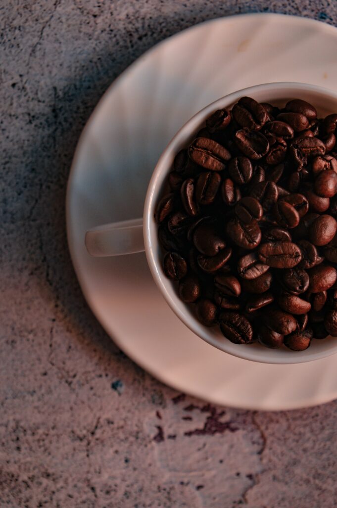 White Cup of Roasted Coffee Beans on Textured Wallpaper Background
