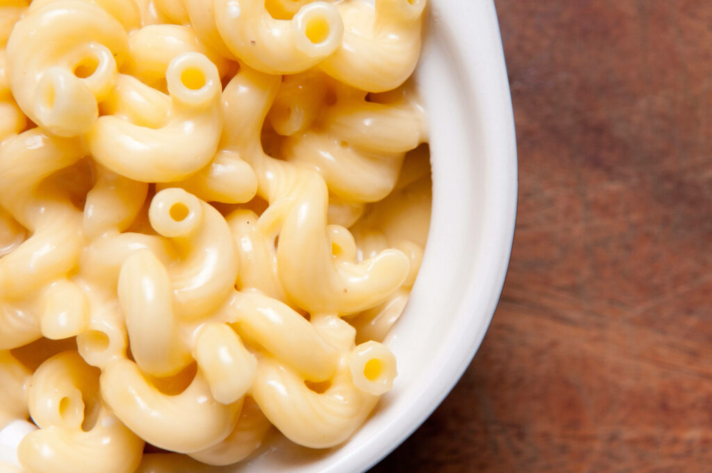 Creamy Mac and Cheese Close-Up in a Ramekin on Rustic Wood Wallpaper
