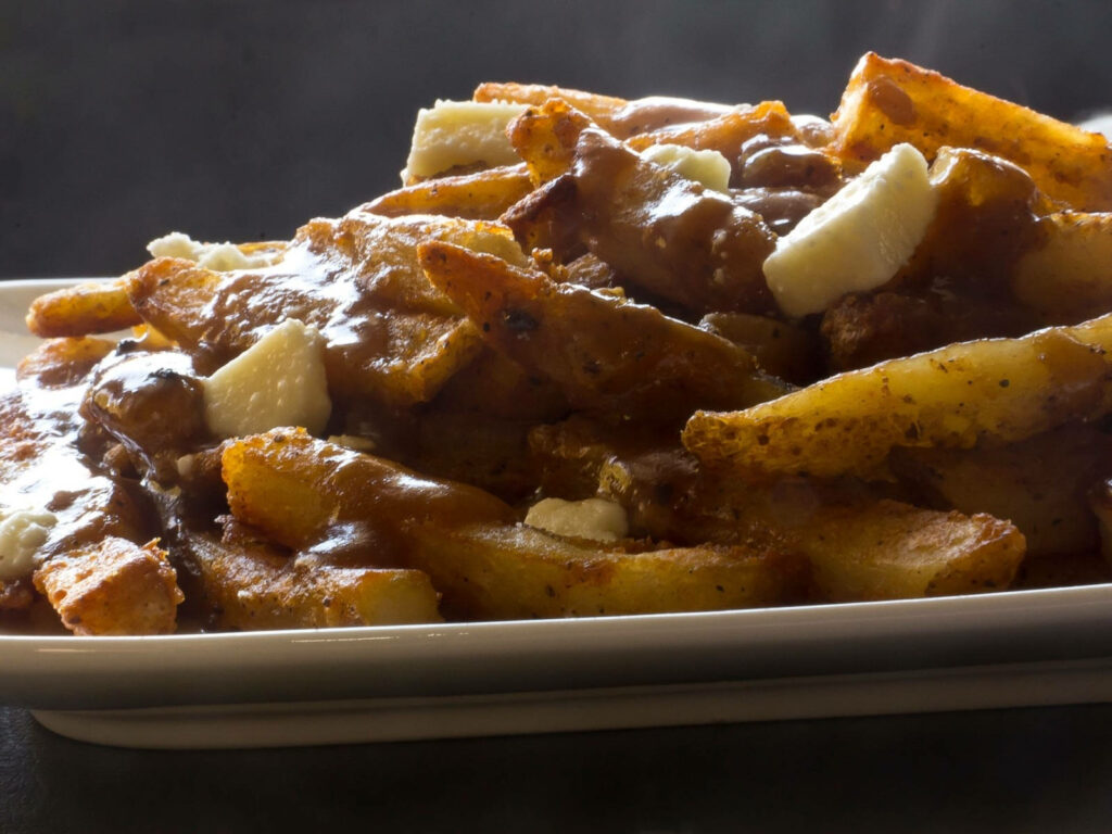 Canadian Poutine Close-Up: Crispy Fries, Gravy & Cheese Curds Wallpaper
