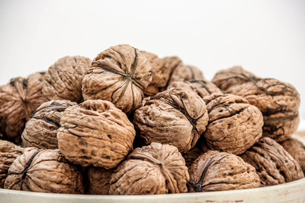 Textured Ripe Walnuts in Shells - Earthy Tones Wallpaper Background