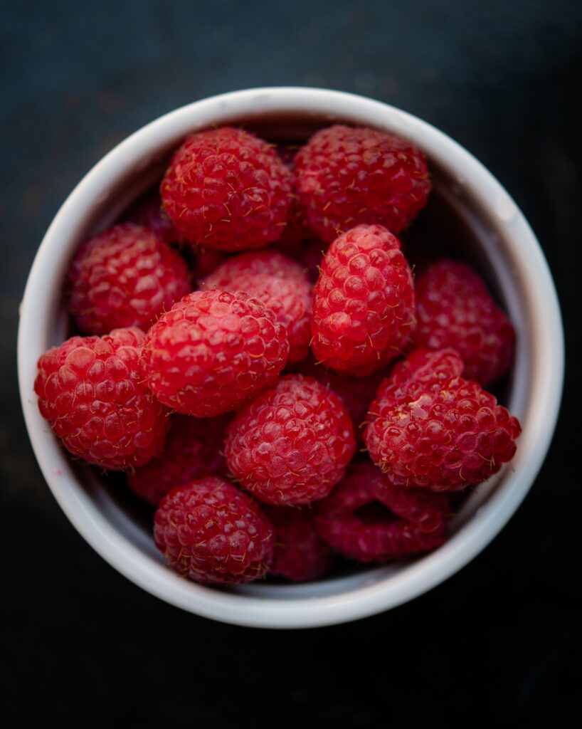White Cup with Fresh Red Raspberries - Captivating Wallpaper Background
