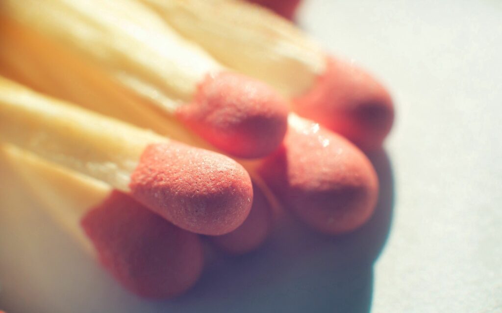 Textured Wooden Matches with Red Tips - Softly Lit Wallpaper Background