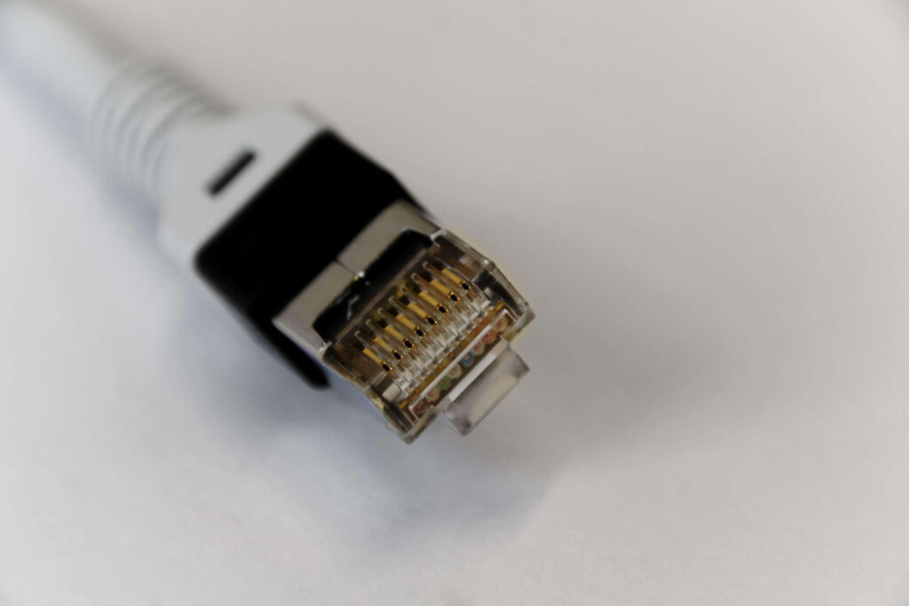 Close-up of Ethernet cable connector with transparent casing on soft blurred background wallpaper