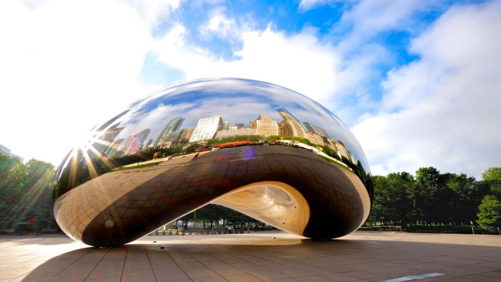 Cloud Gate sculpture in Chicago reflecting city skyline and blue sky in sunlight wallpaper background
