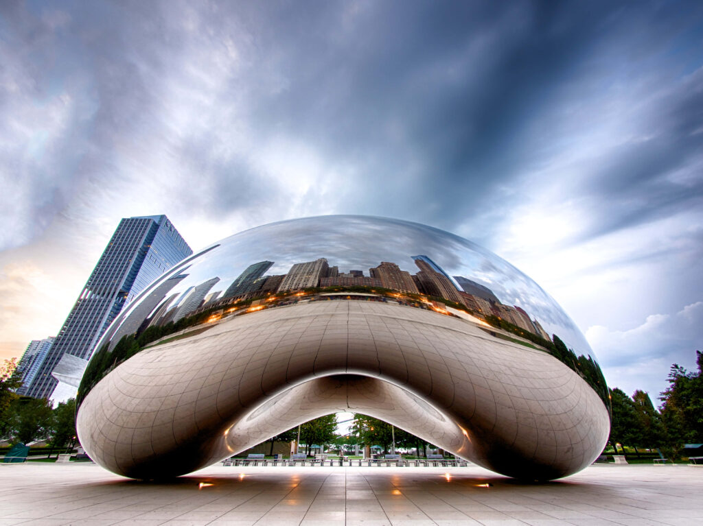 Cloud Gate sculpture in Chicago reflecting city skyline under dramatic dark swirling clouds wallpaper