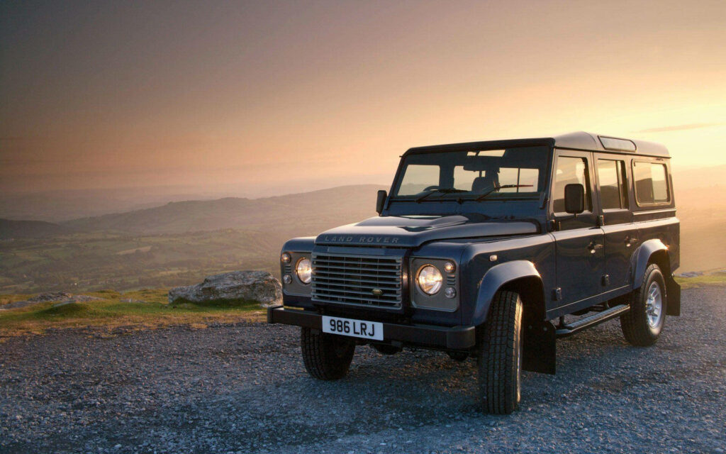 Stunning Coal Black Land Rover Defender Wallpaper Against Countryside