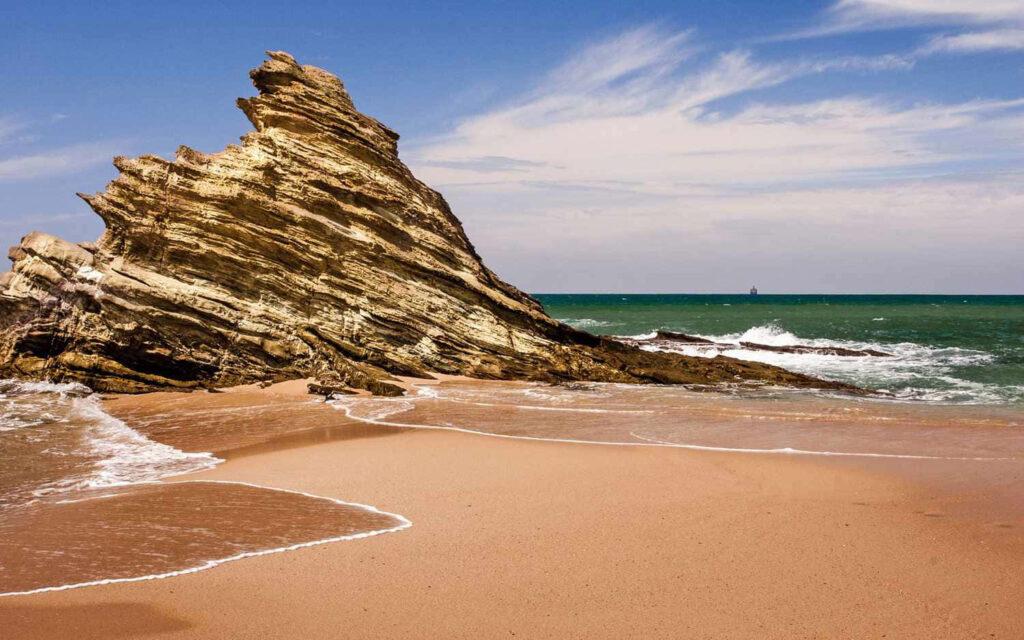 Serene Coastal Wallpaper: Tranquil Beach & Rock Formation Scene
