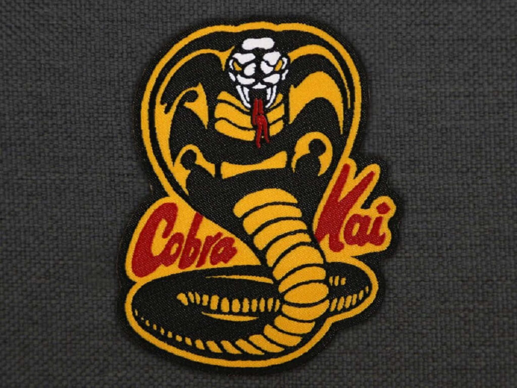 Iconic Cobra Kai Wallpaper: Yellow Cobra Logo & Bold Red Text