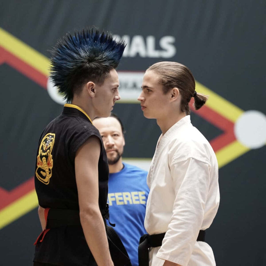 Cobra Kai Showdown Wallpaper: Fierce Martial Arts Face-Off