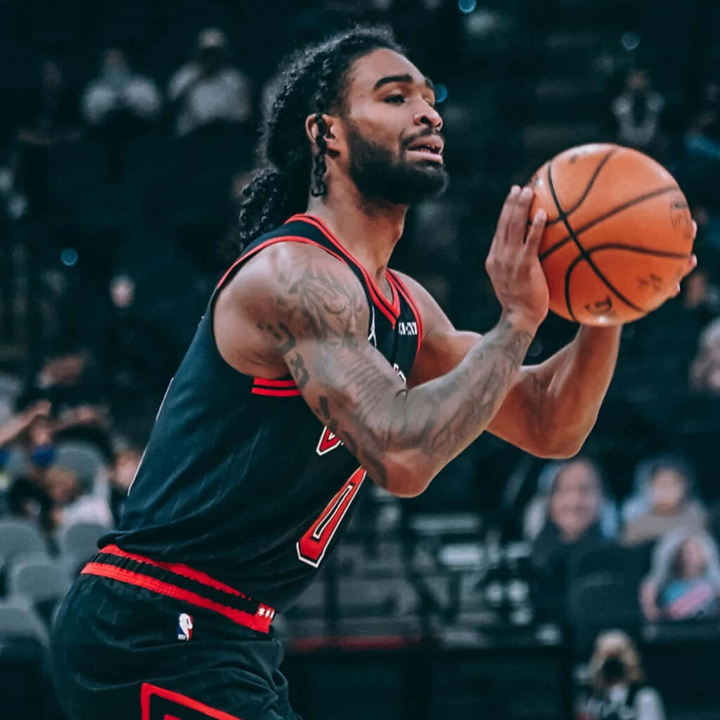 Coby White in black Bulls jersey shooting basketball showcasing focus and athleticism on court Wallpaper