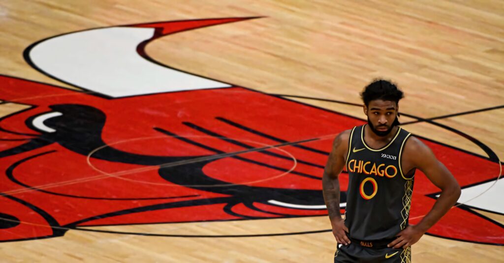 Coby White on Chicago Bulls court with focused expression in black uniform and bold bull logo Wallpaper