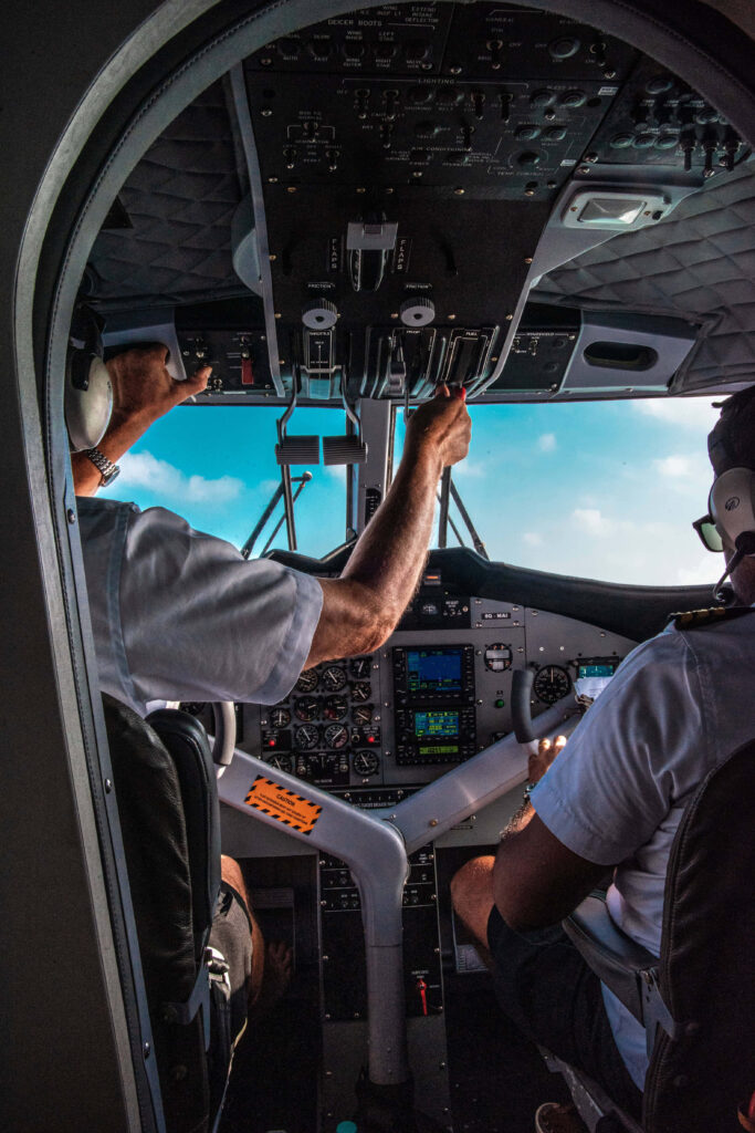 Cockpit view of two pilots flying modern aircraft with detailed avionics under clear blue sky Wallpaper