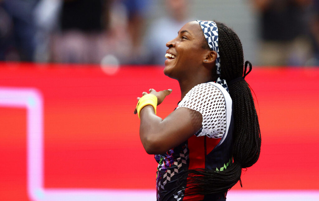 Coco Gauff celebrating on court vibrant red background tennis player athletic gear braids wallpaper