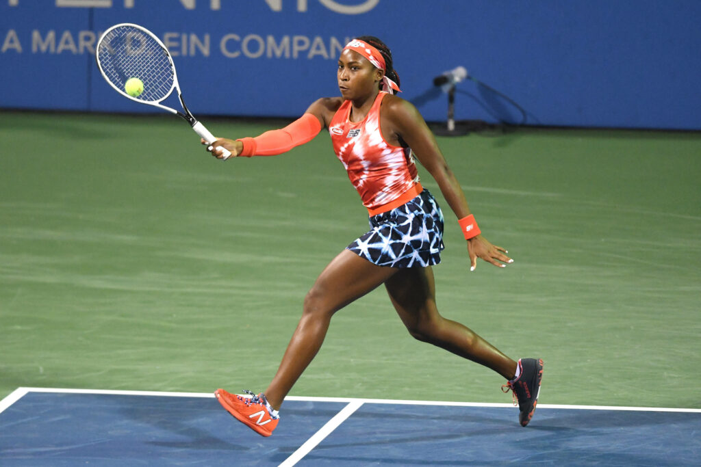 Coco Gauff intense tennis action in vibrant red blue outfit dynamic movement wallpaper background