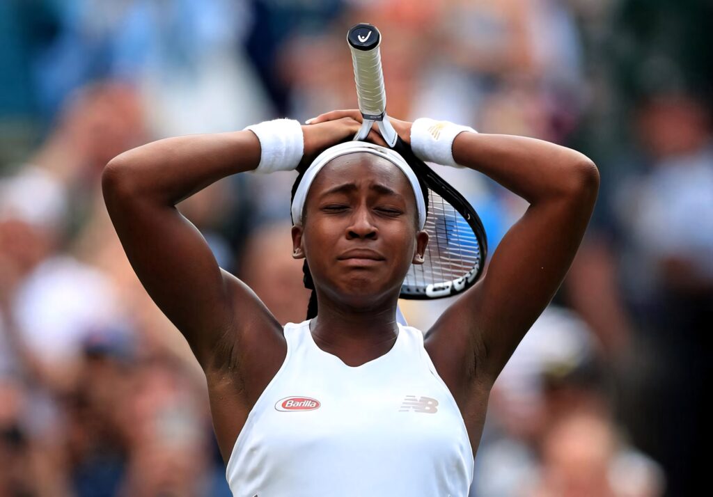 Coco Gauff powerful tennis moment eyes closed arms raised athletic focus high stakes match Wallpaper