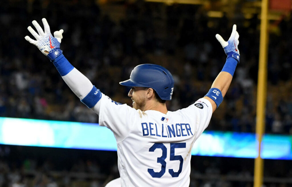 Cody Bellinger celebrates in Dodgers uniform with stadium lights and crowd blurred background Wallpaper