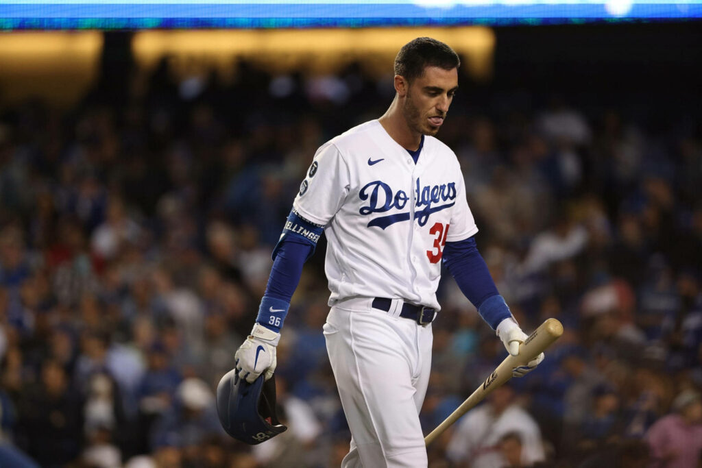 Cody Bellinger in Dodgers uniform focused with bat under stadium lights during intense game night Wallpaper