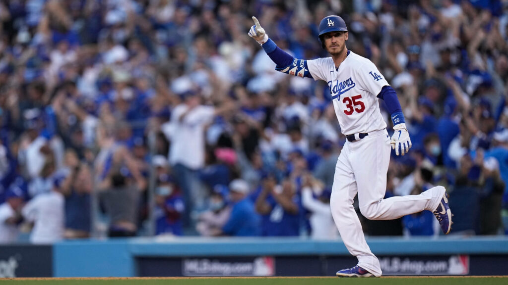 Cody Bellinger Dodgers number 35 mid-stride celebrating in vibrant stadium with crowd background Wallpaper