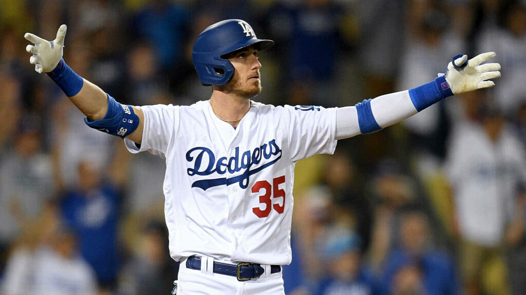 Cody Bellinger Dodgers number 35 jersey arms wide in spotlight action-packed baseball game moment Wallpaper