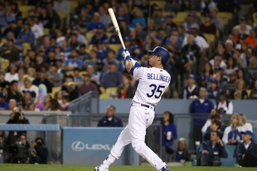 Cody Bellinger swinging powerfully in Dodgers uniform under bright stadium lights action shot Wallpaper