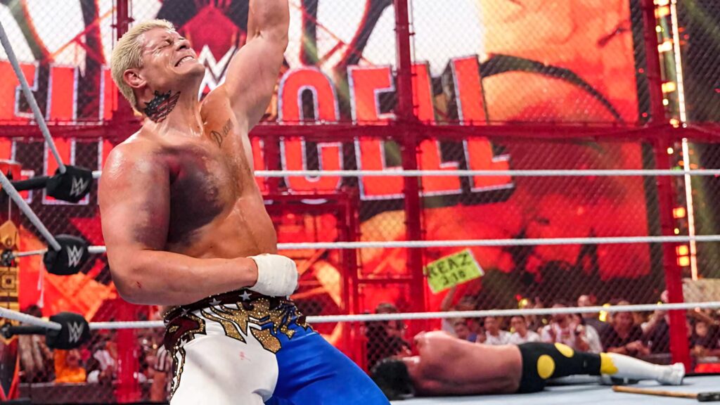 Cody Rhodes victorious in WWE Hell in a Cell arena with dramatic red orange lighting and steel cage Wallpaper