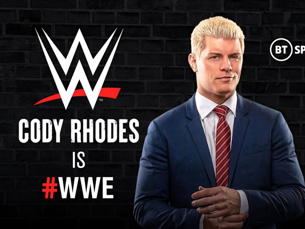 WWE wrestler Cody Rhodes in blue suit and red tie stands confidently by dark brick wall wallpaper